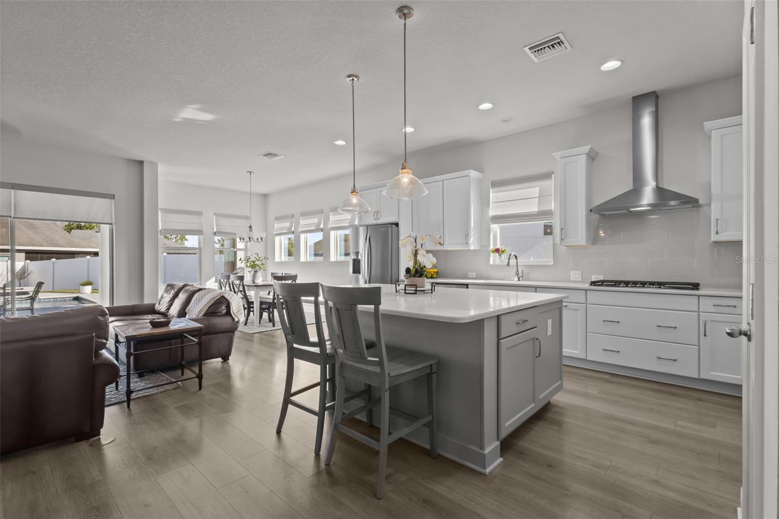 Kitchen -  spacious island, stylish backsplash, built-in stainless steel appliances, and a natural gas range