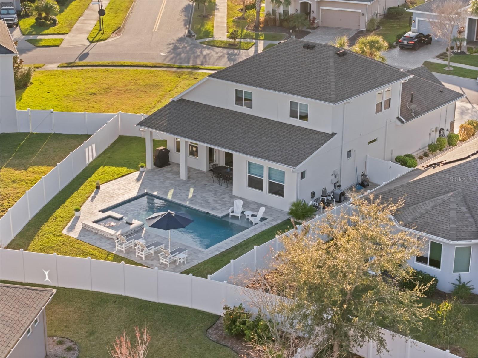 Aeiral showing pool, patio, and fenced in pie shaped lot