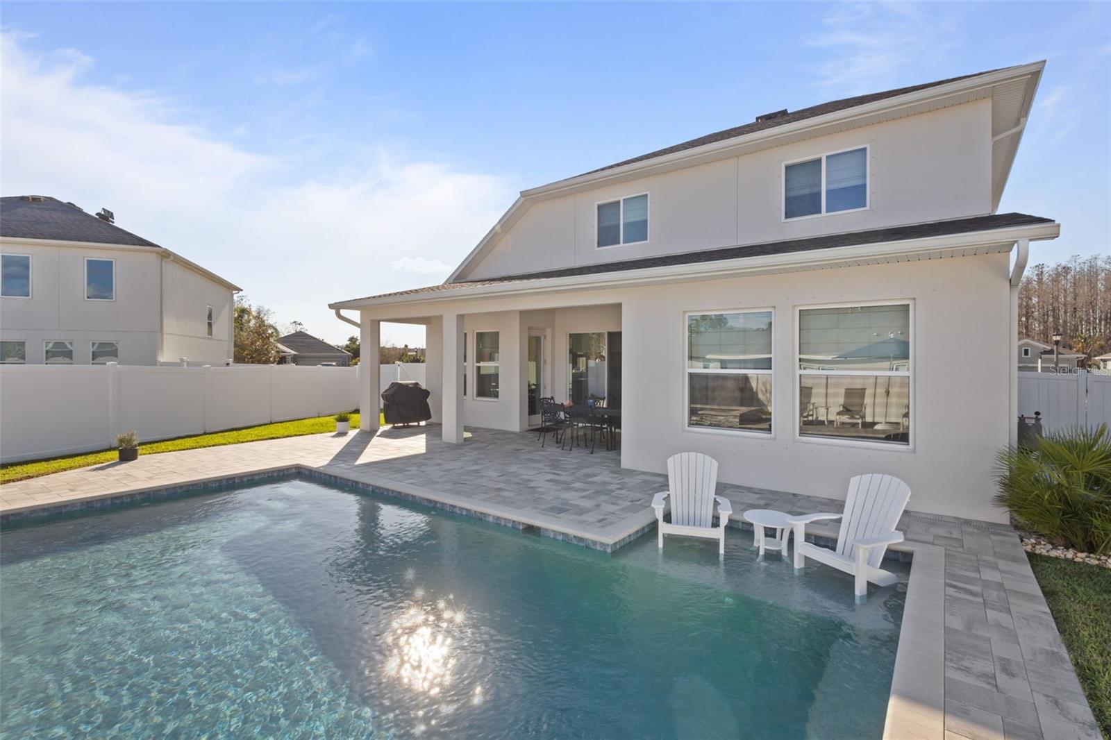 The outdoor retreat is the highlight of this home, featuring a custom pool and spa with Badu jets for lap swimming, a sun shelf with bubbler, and LED color lighting