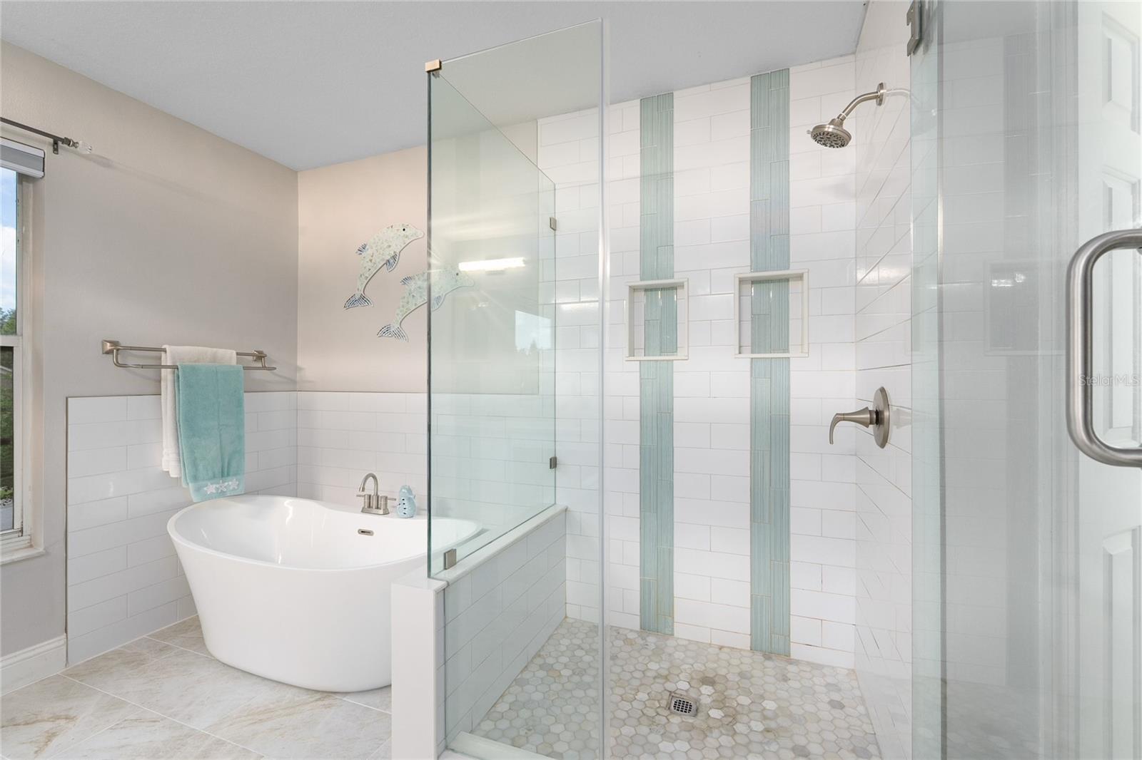 Large walk in shower with stylish floor to ceiling tile.