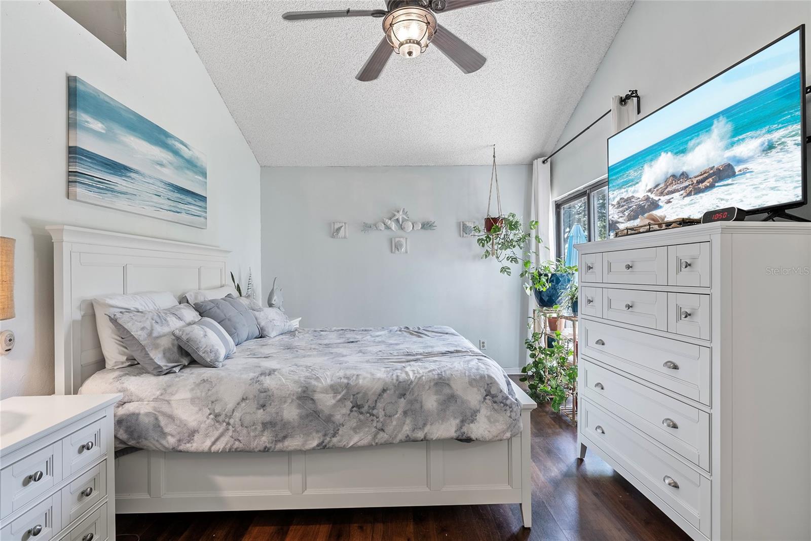 View of the primary bedroom.  Sliding glass doors next to the dresser lead to the back patio and back yard.