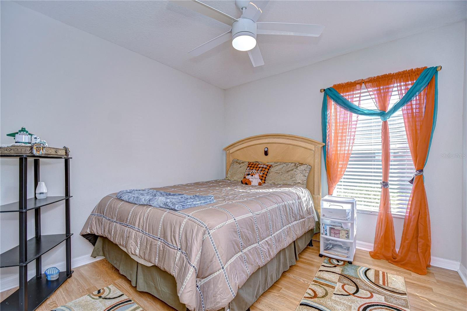 Cozy second bedroom with natural light .