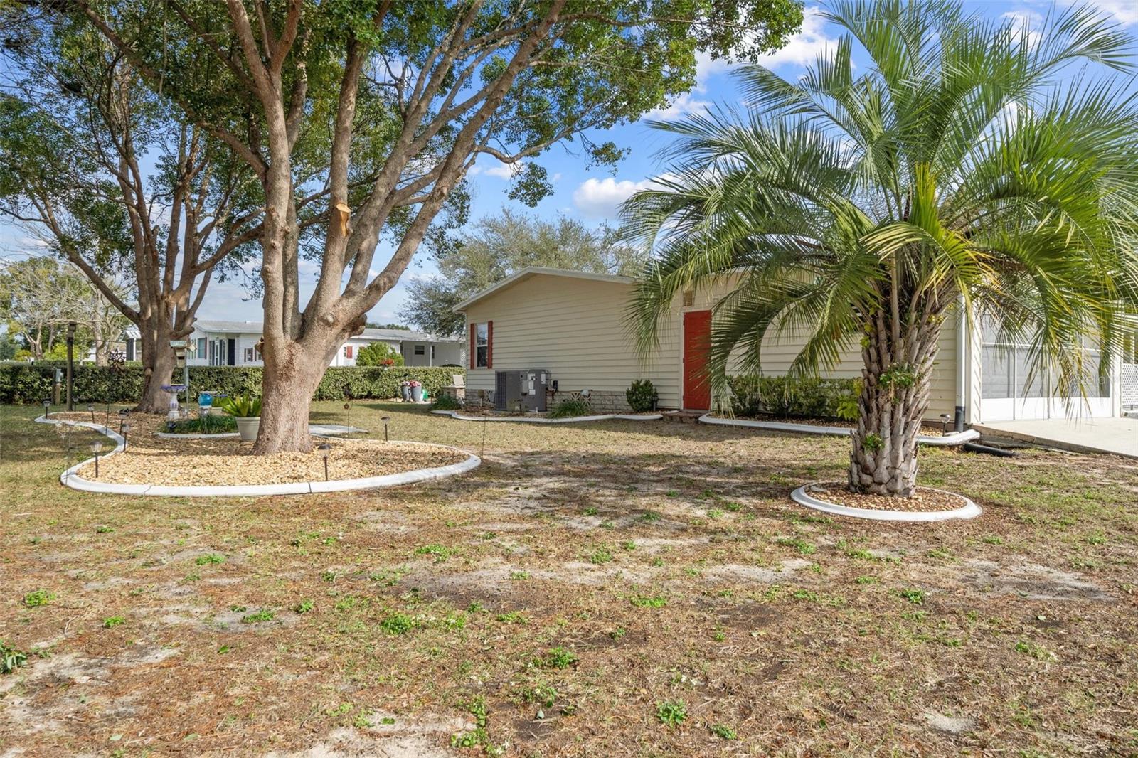 Back of home with curbing around landscaping