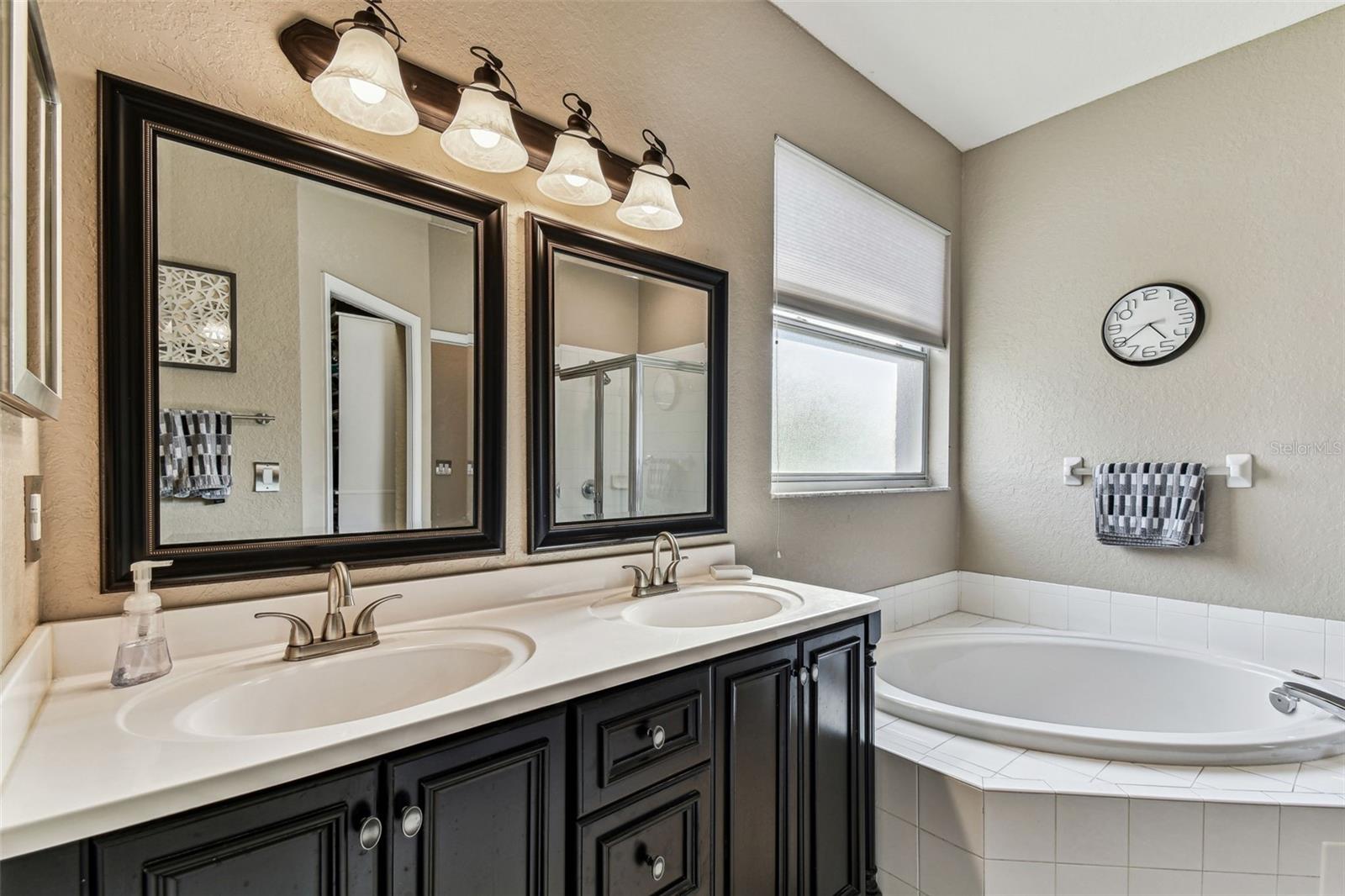 En-suite primary bath with double vanity and garden tub.