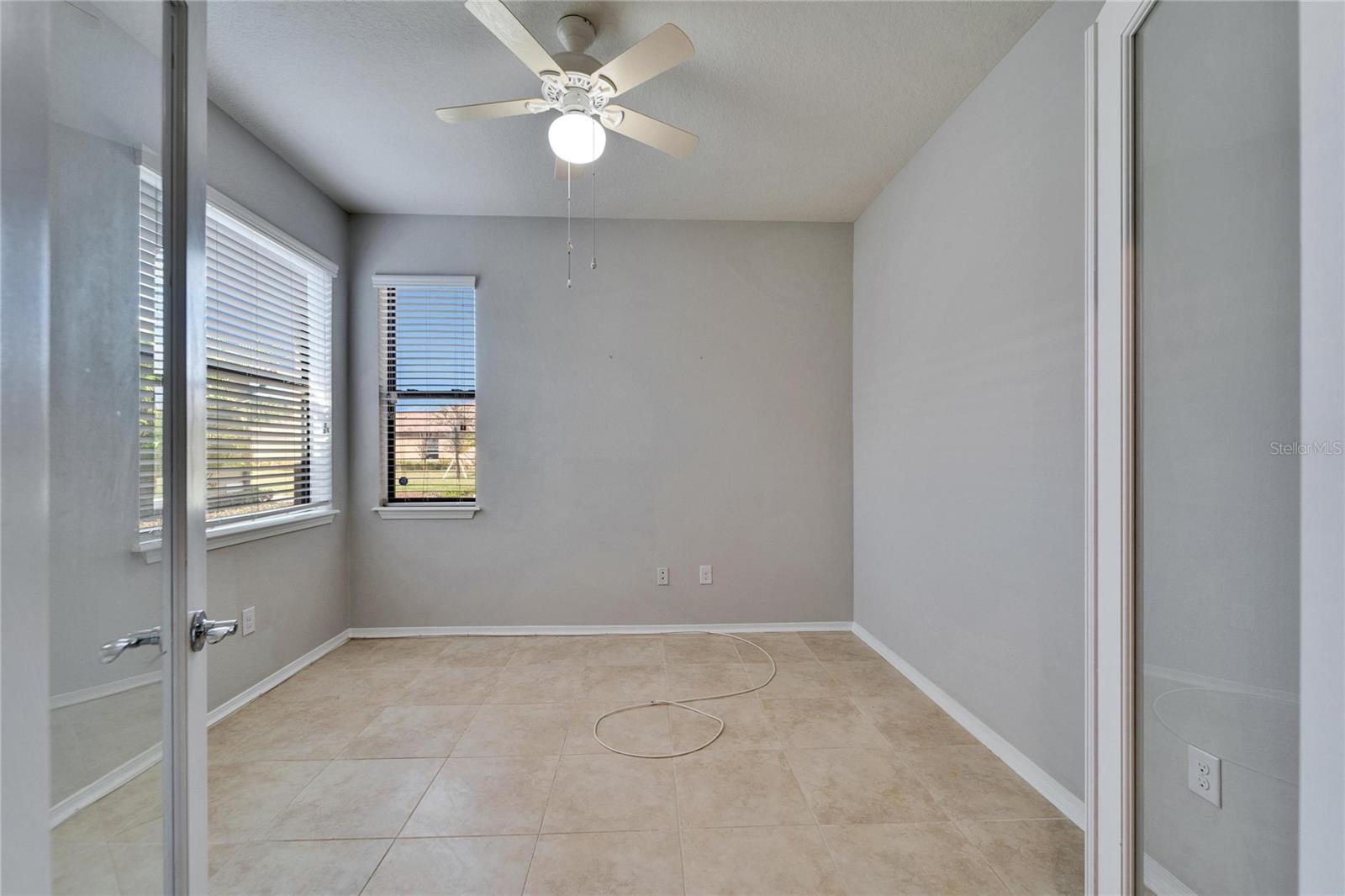 View into the office/bonus room with glass doors open.