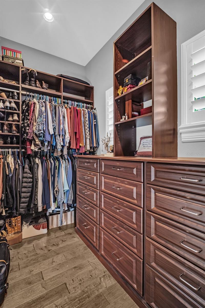 Primary closet (1of2) spacious with built in cabinetry