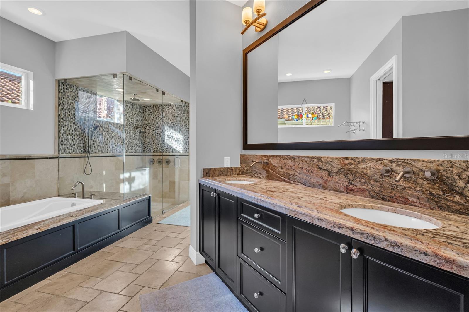 Primary Bath featuring dual sinks, jetted garden tub and large multi shower head glass surround shower