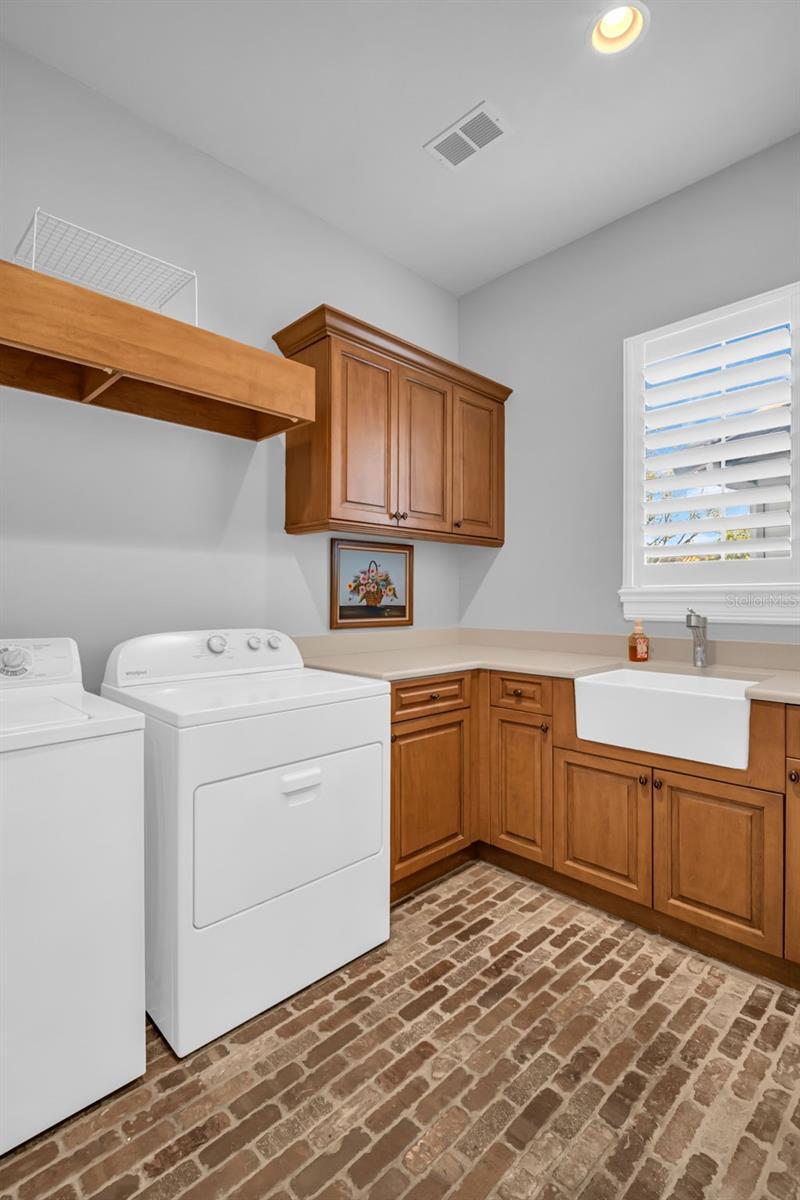 Dedicated laundry room with storage and sink.