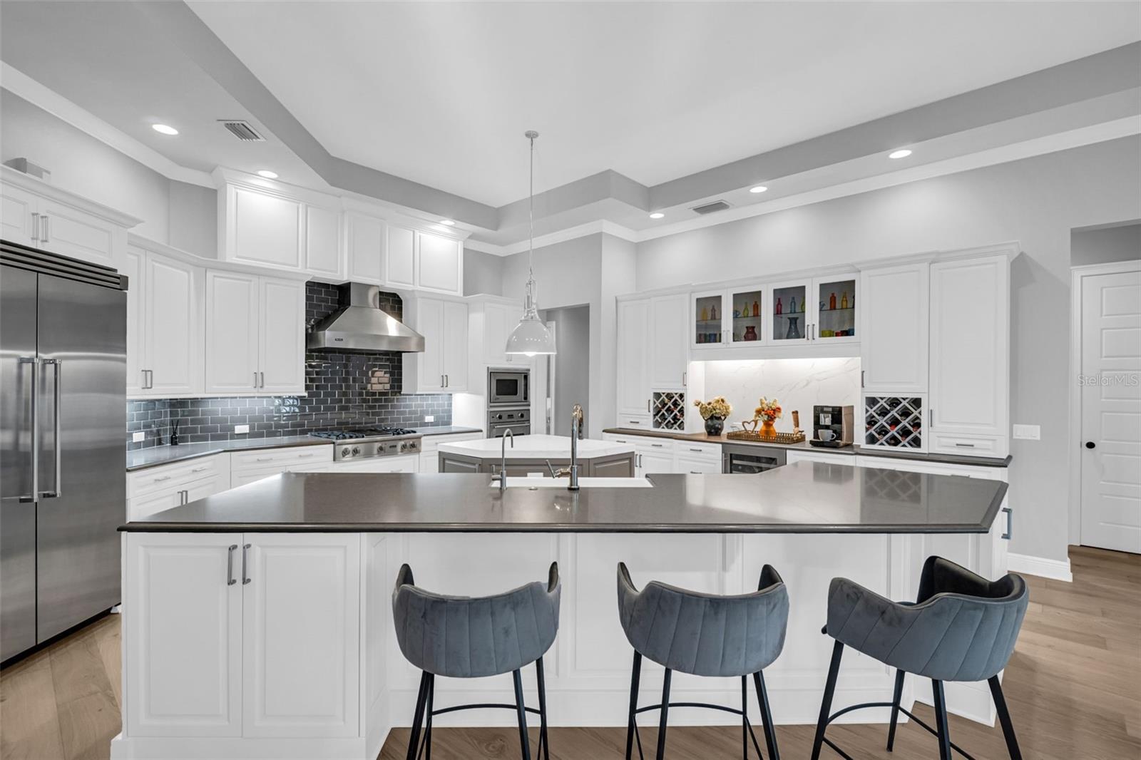 Spacious kitchen with 2 stone counter islands kitchen featuring Viking Professional Series appliances, tons of cabinetry, mini drawer and wine refrigerators.