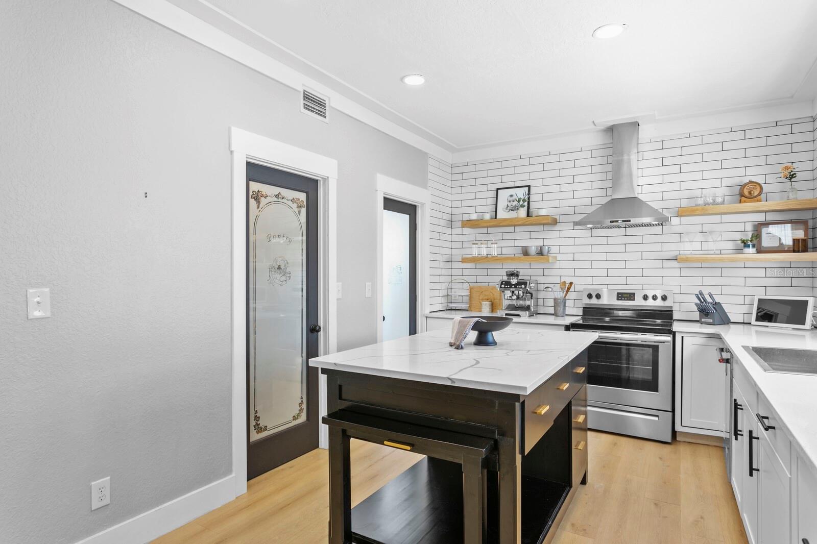 You'll find custom glass doors leading to the large pantry and laundry room