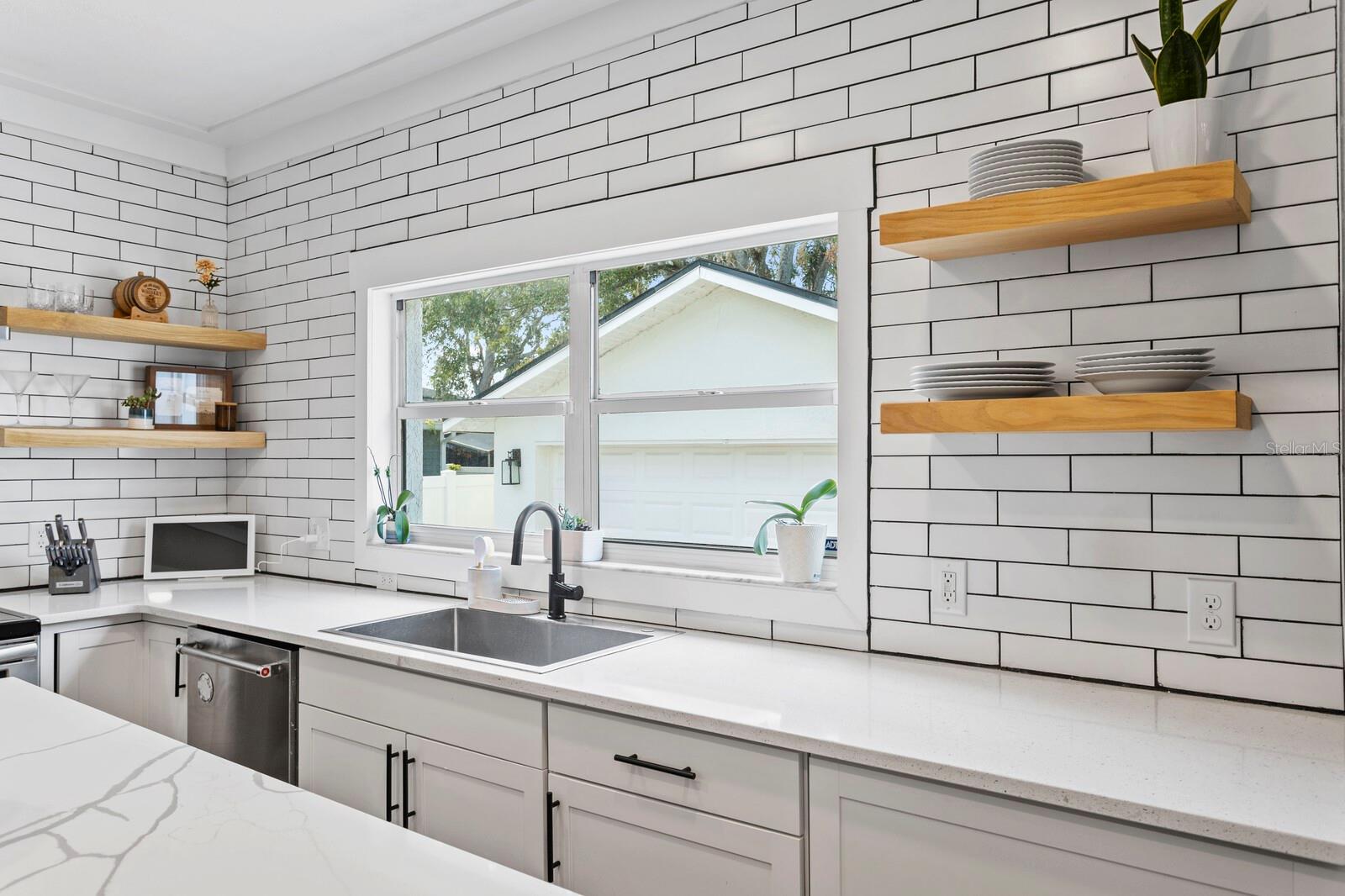 The kitchen has a large window with backyard views