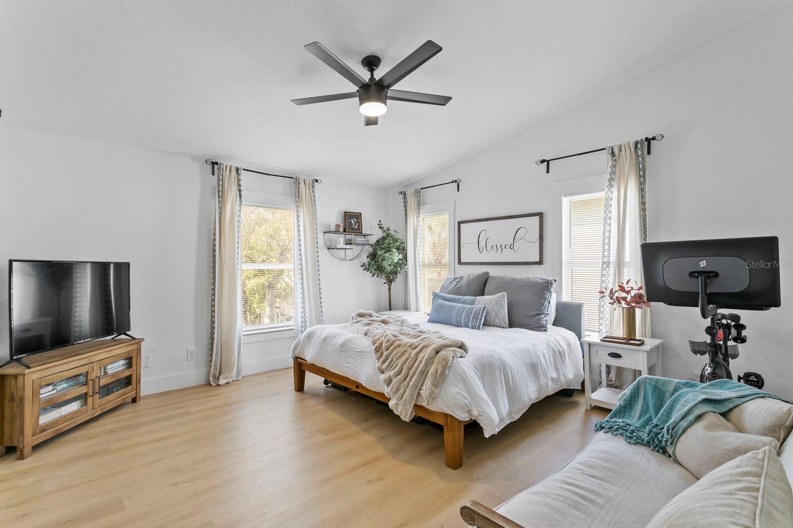 The primary suite has tons of natural light and a vaulted ceiling