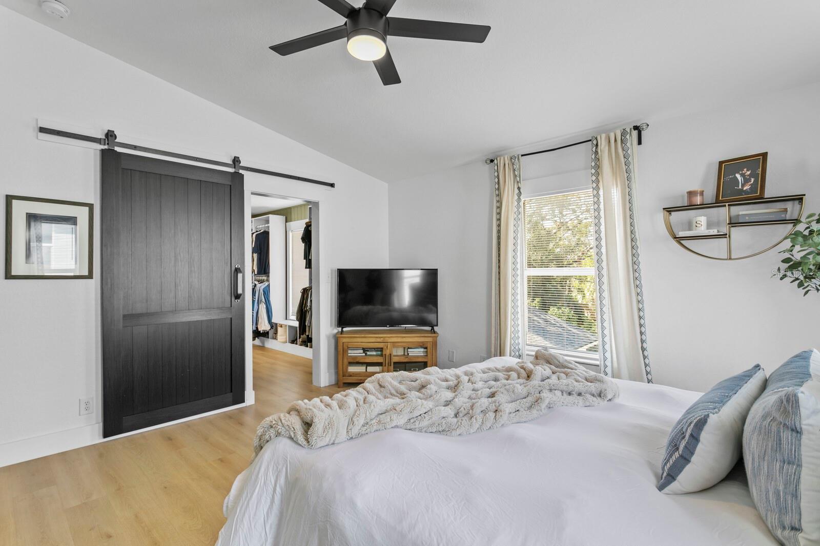 A custom barn door leads into the large walk-in close and primary bath