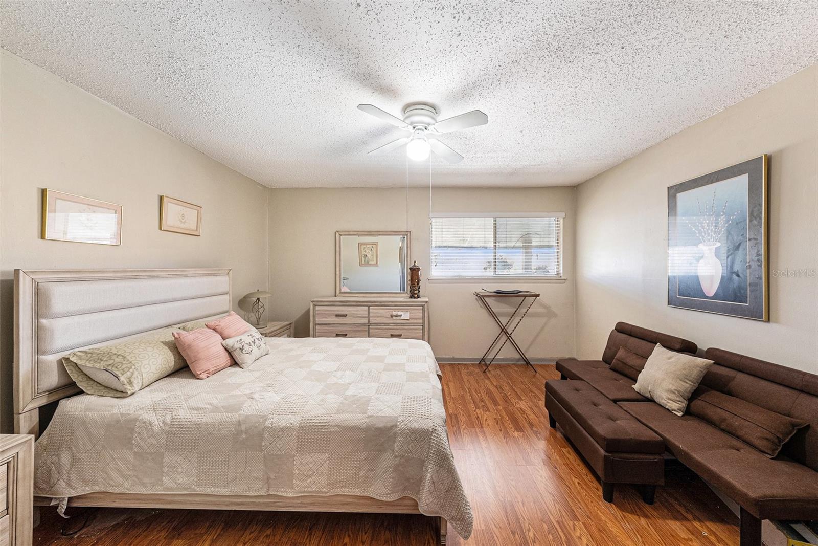 Spacious primary bedroom with ceiling fan.