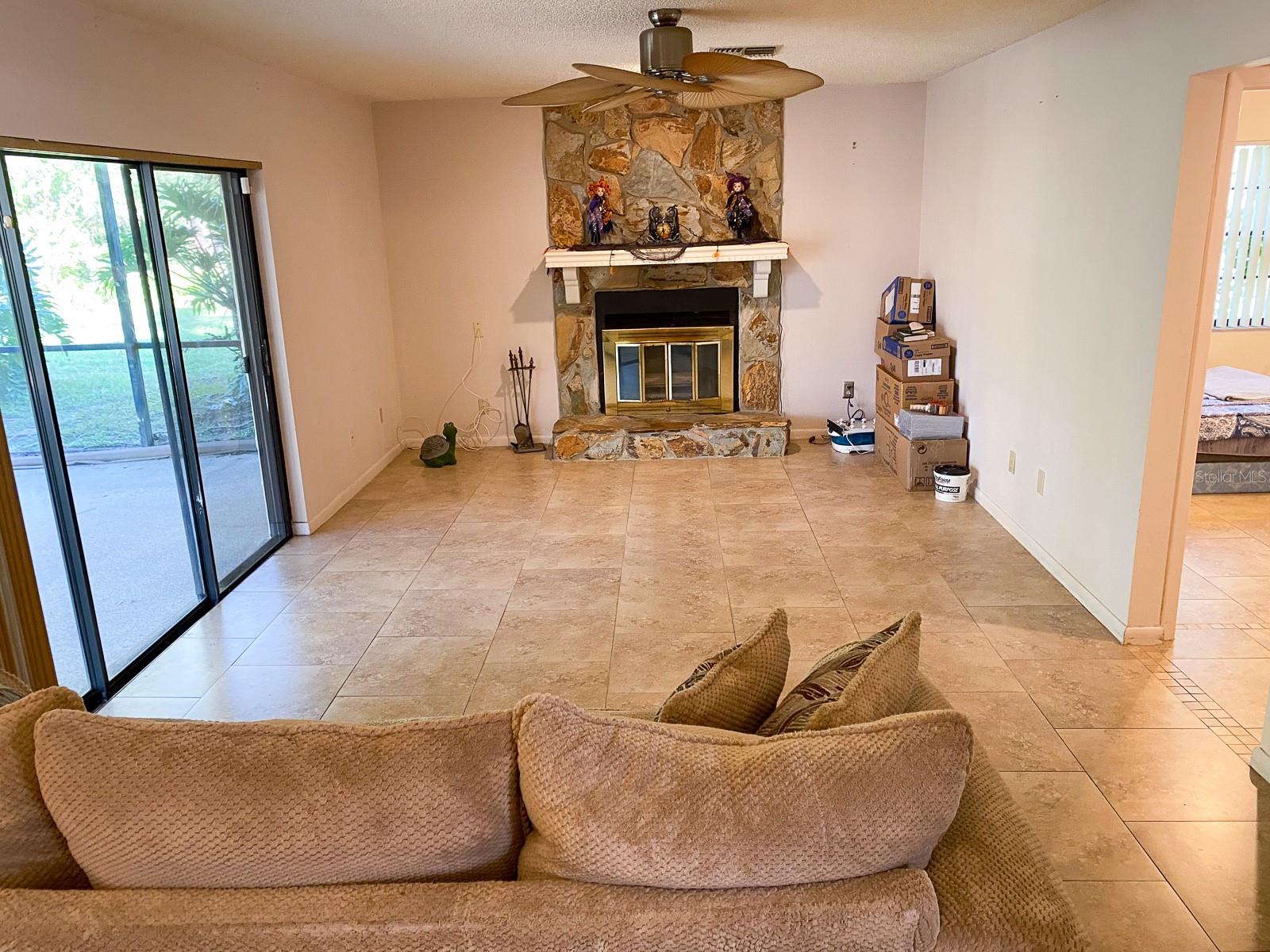 Family Room is next to guest bedroom and bathroom. Sliding door goes to patio and screened pool.