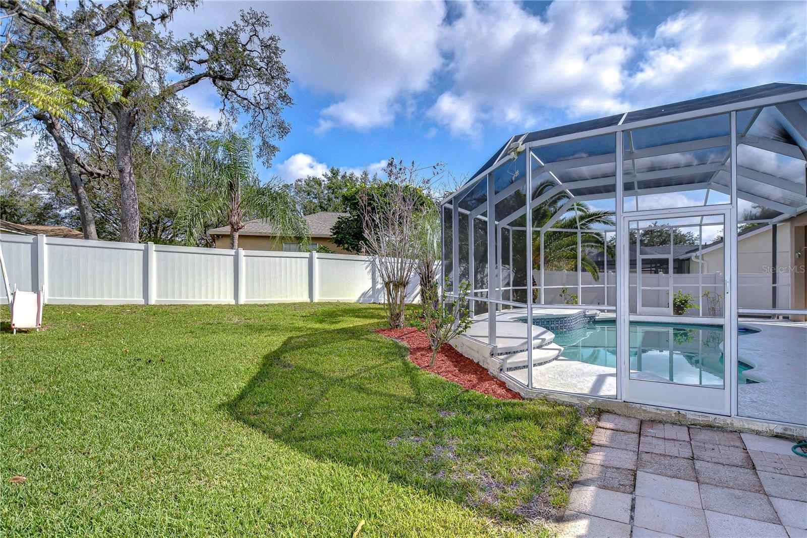 Relax in your private paradise, complete with a screened-in pool and lush backyard.