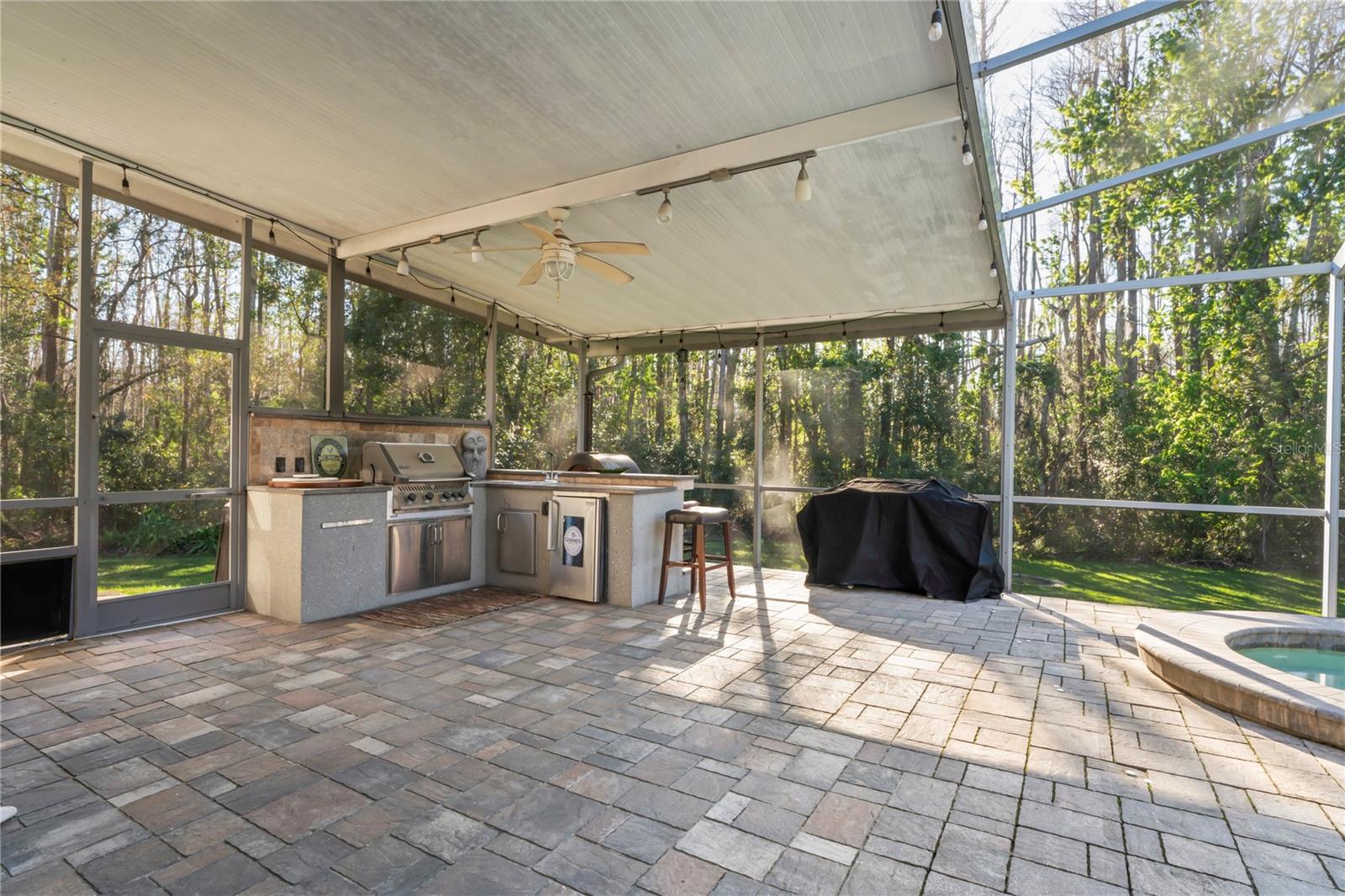 Outdoor kitchen with grill and wet bar.