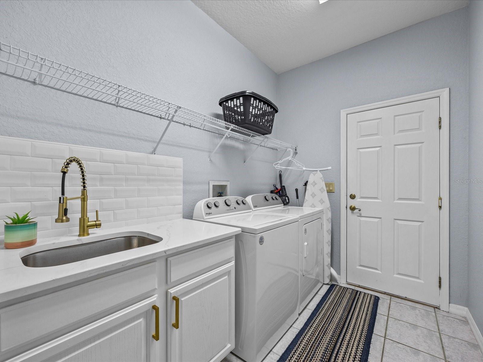 Laundry with updated counter space, sink and hanging rank..access to the garage