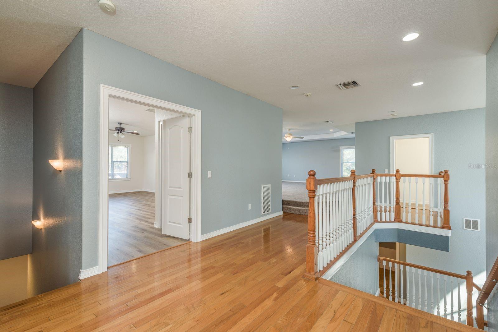 Upstairs hall showing double door entry to 2nd floor Primary bedroom.