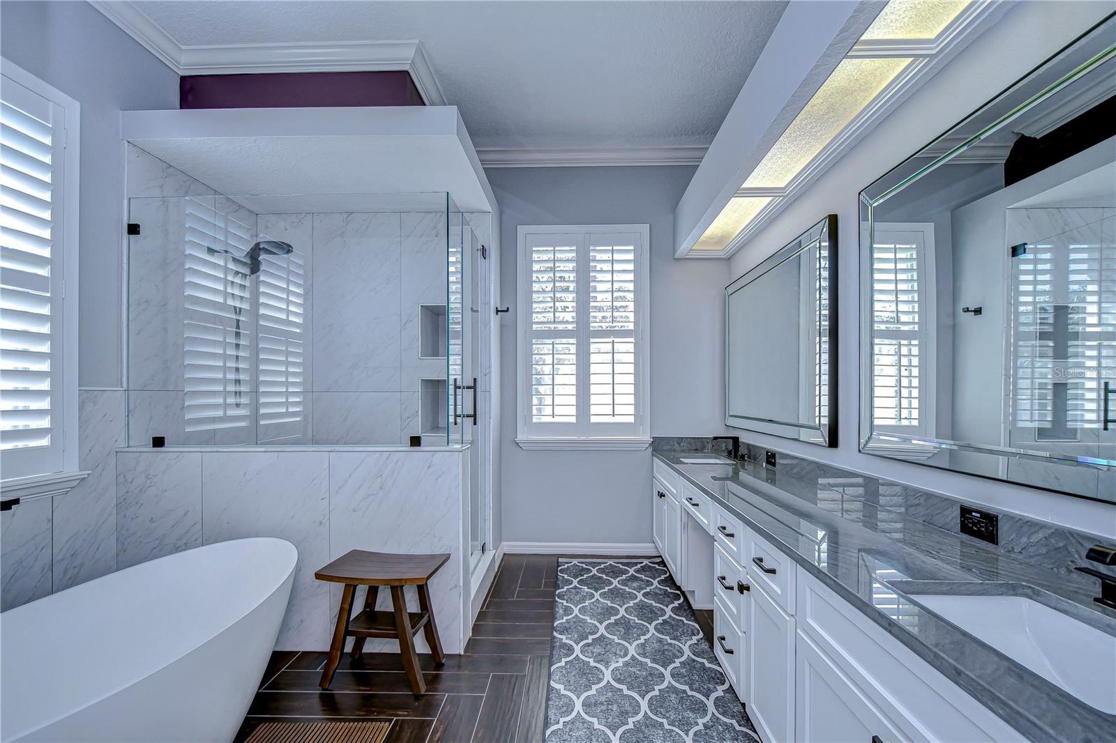 Step into your personal spa retreat with this luxurious bathroom, featuring a sleek glass shower, elegant soaking tub, and expansive dual vanity.