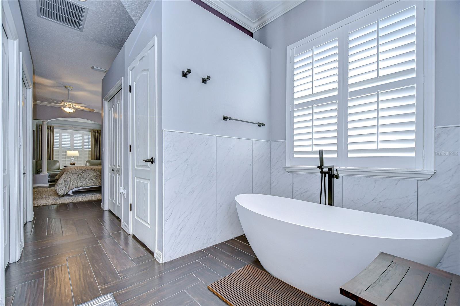 Indulge in elegant relaxation with a spa-like bathroom featuring a sleek free-standing tub and abundant natural light.