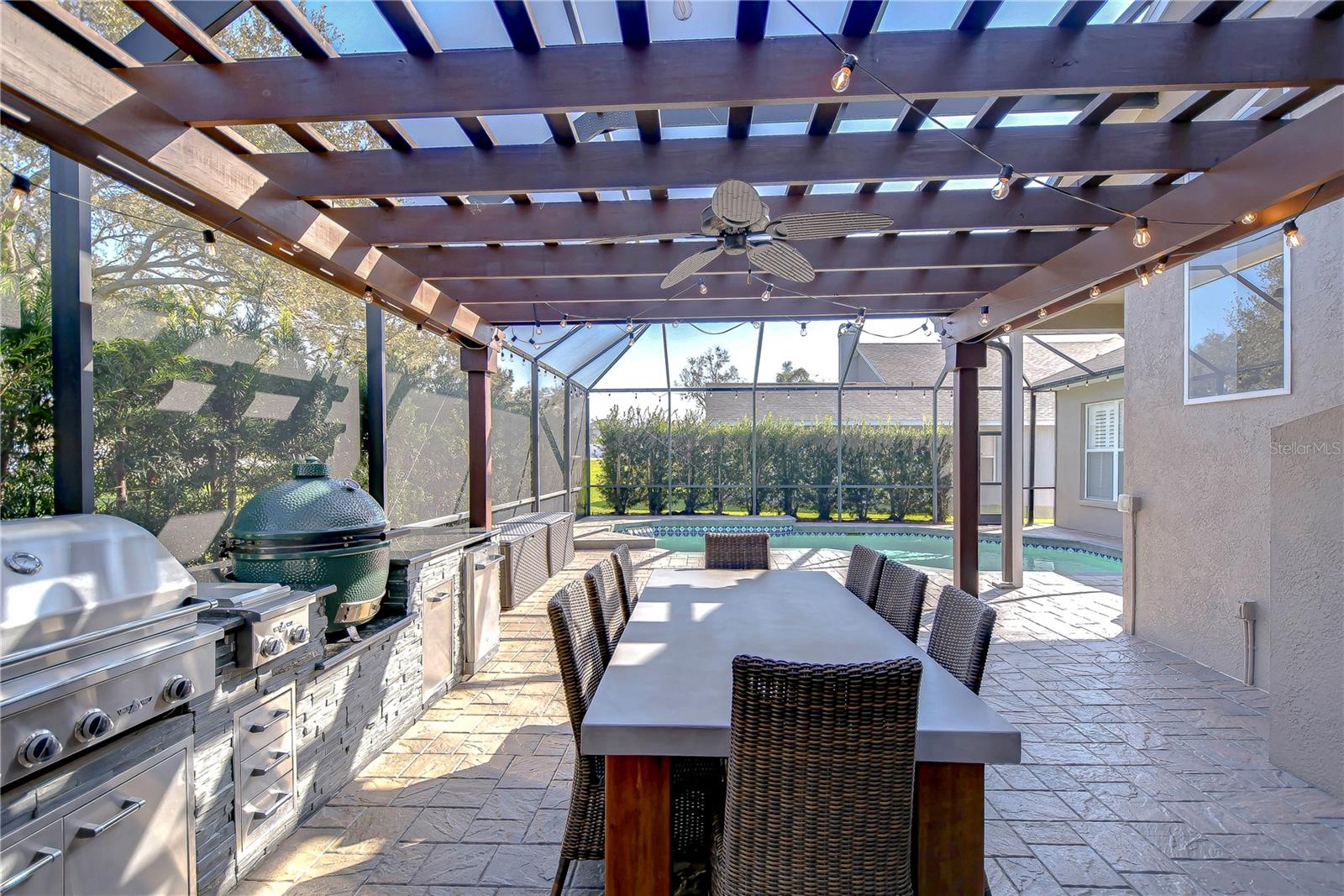 Covered for comfort and equipped for entertaining, his stunning outdoor kitchen and dining area is perfect for hosting.