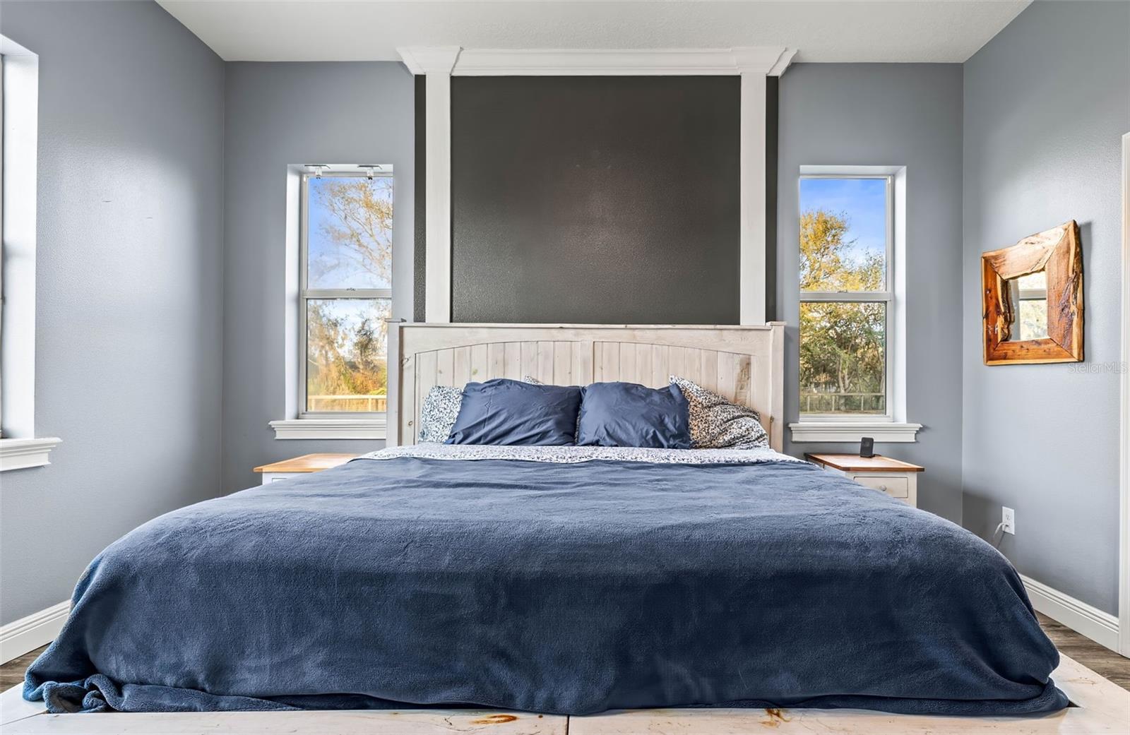 Primary bedroom with plenty of windows and natural light as well as a decorative wall accent.