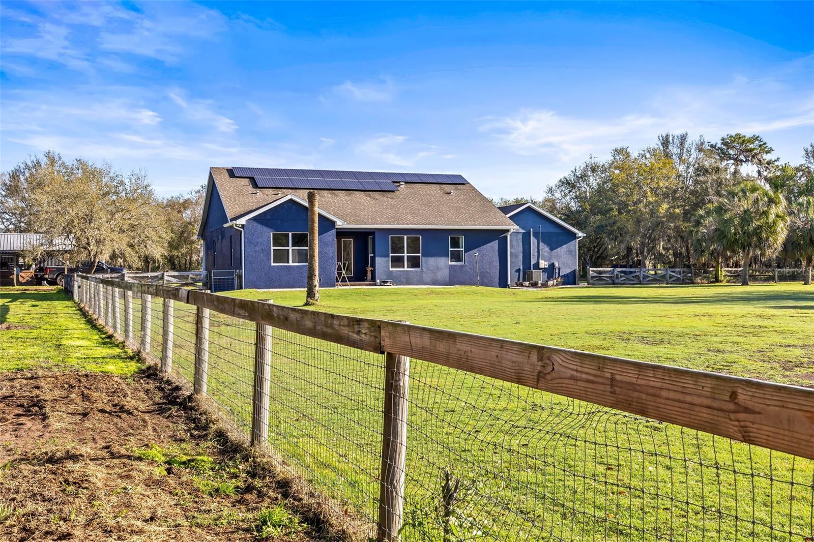 Back of house and back yard which is approximately 1 acre and fenced.