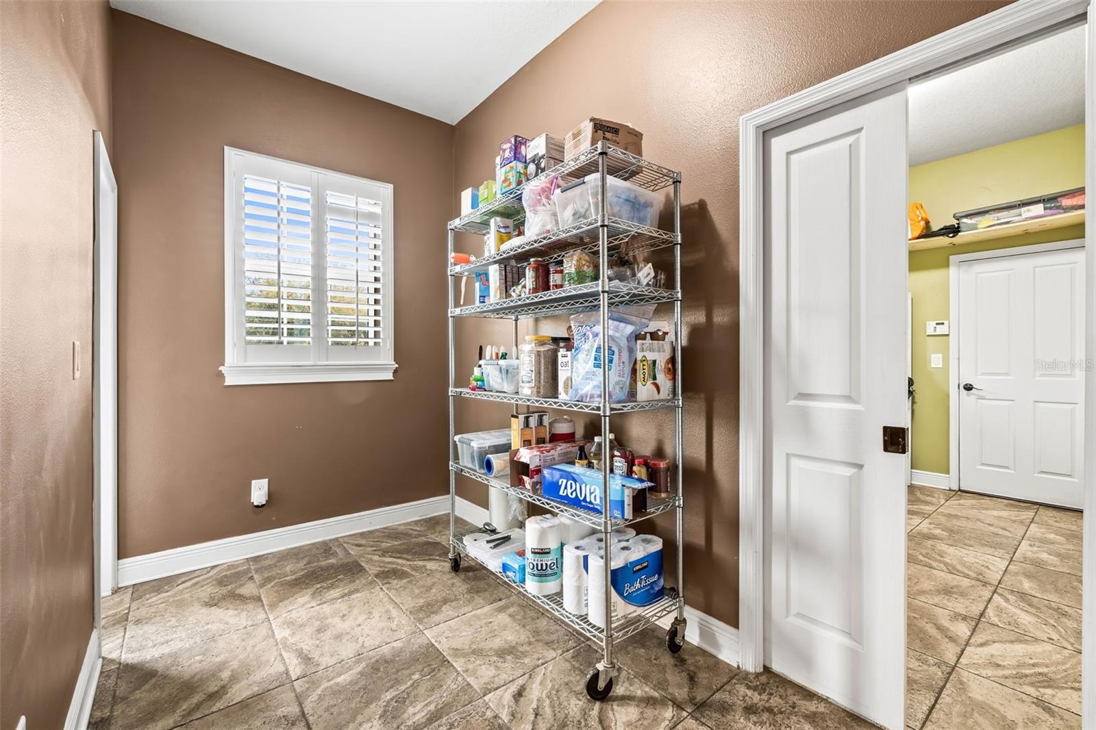 Flex room located between the laundry room and the kitchen. A pocket door separates the laundry room from this room and the rest of the house. There is a door from this room to the front porch.