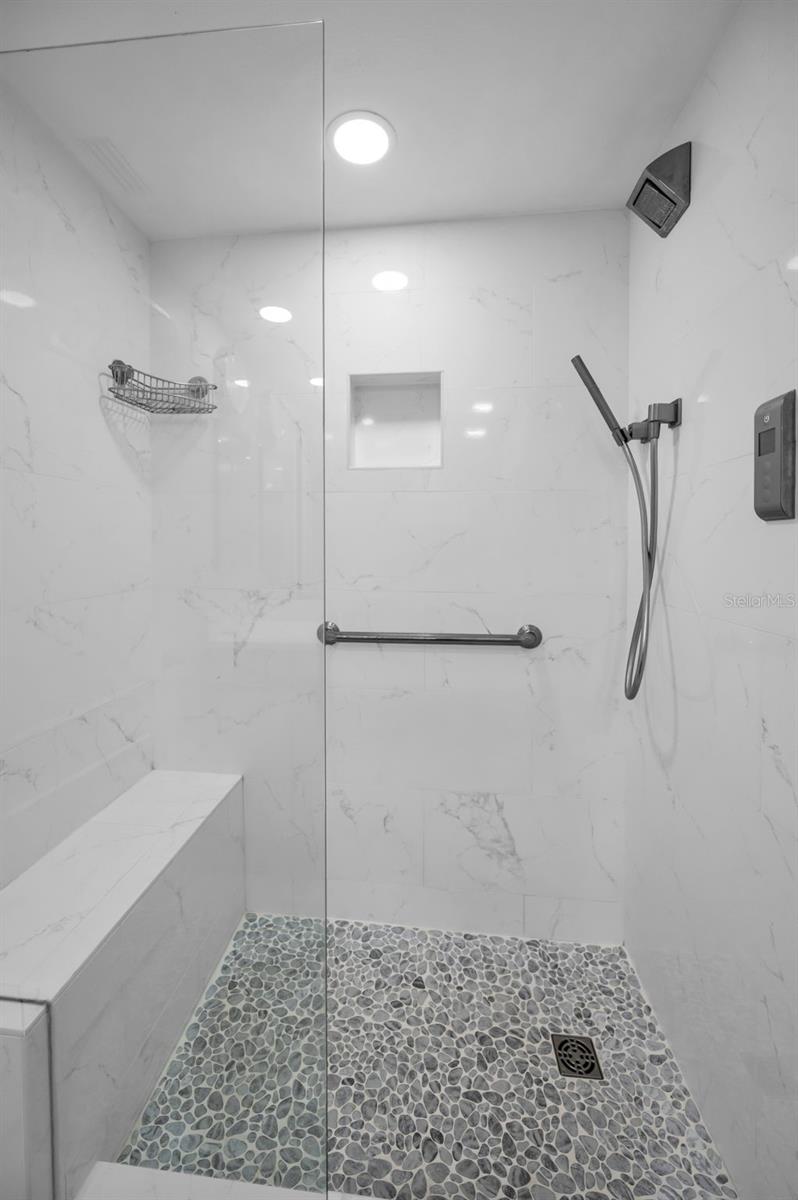 Master bath walk in shower with bench, rain head shower and temp and time controls!