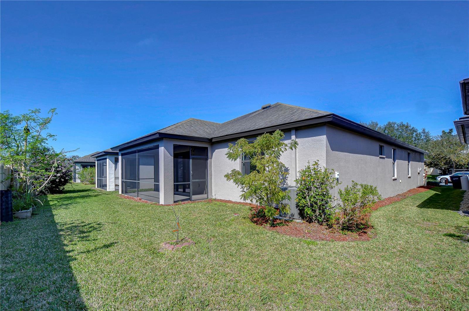 Spacious backyard with screened patio, perfect for cozy gatherings and enjoying sunny Florida days.