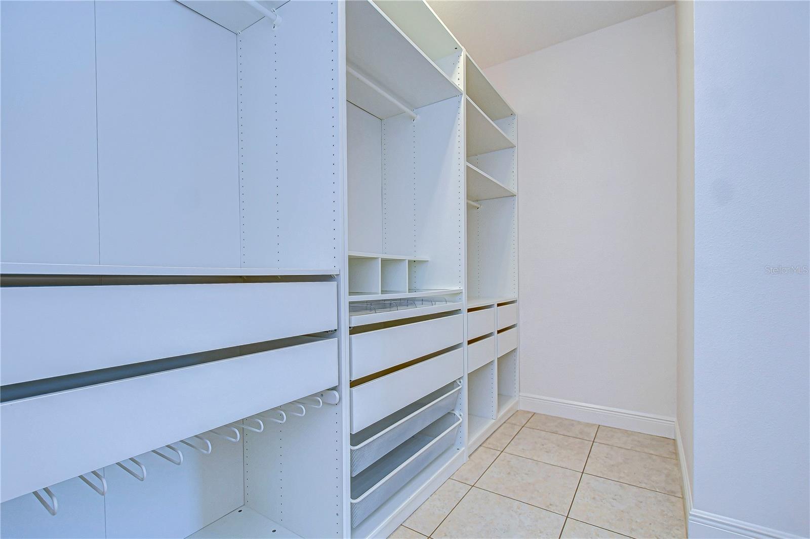 This spacious closet features sleek built-in storag