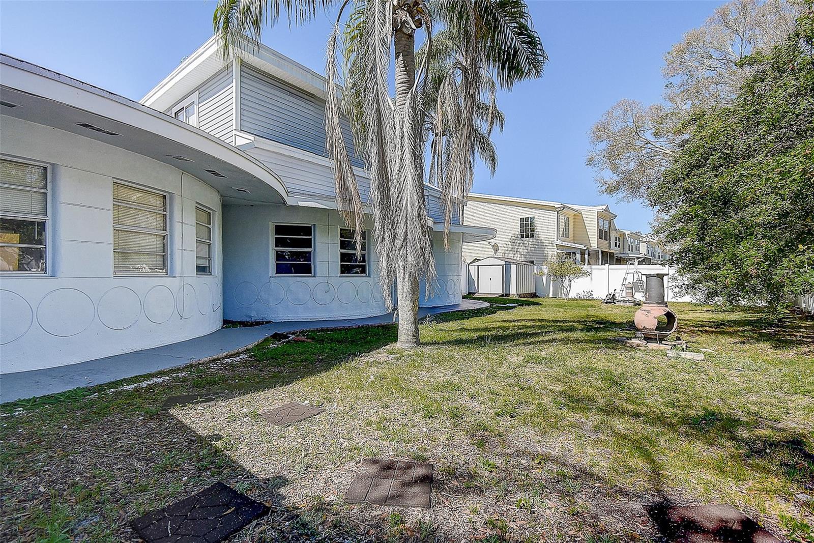 Large side/back yard behind white vinyl fence