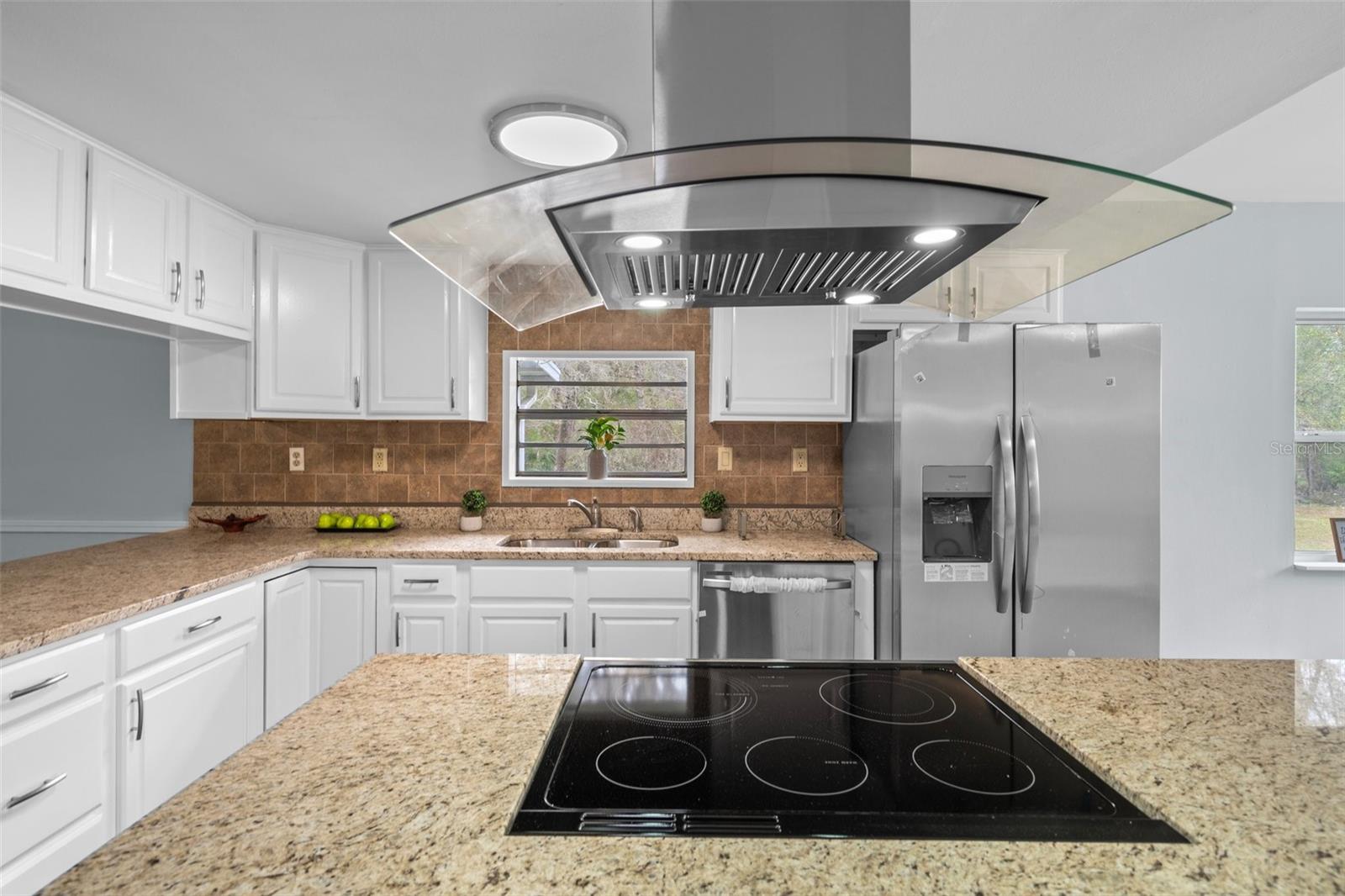 What a gorgeous brand new range hood and cook top. Notice the upgraded stainless steel dishwasher and refrigerator in the background