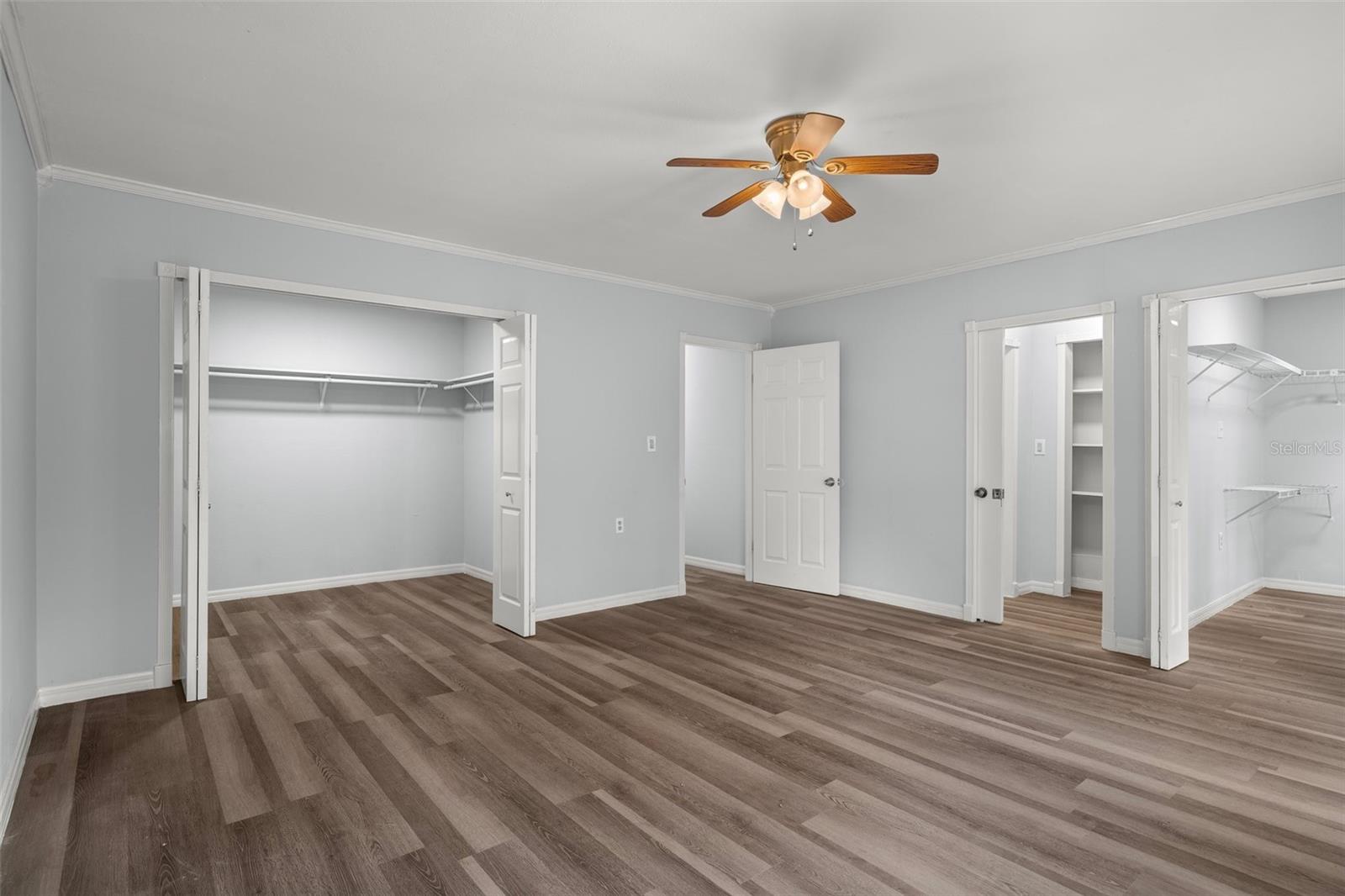 Another view of the master bedroom with both walk-in closets and doorway to the master bathroom