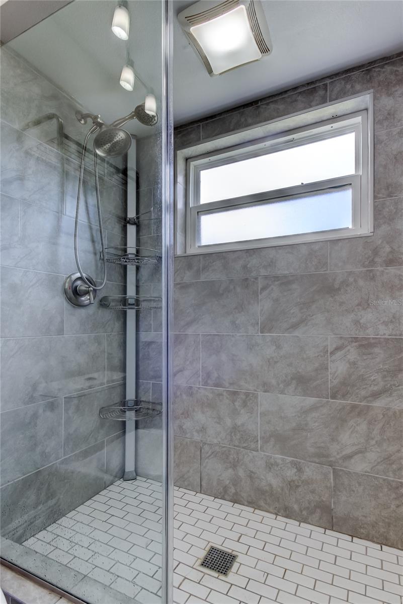 Hallbath Features a Walk-in Shower with Stylish Tiles & a Window to Vent!