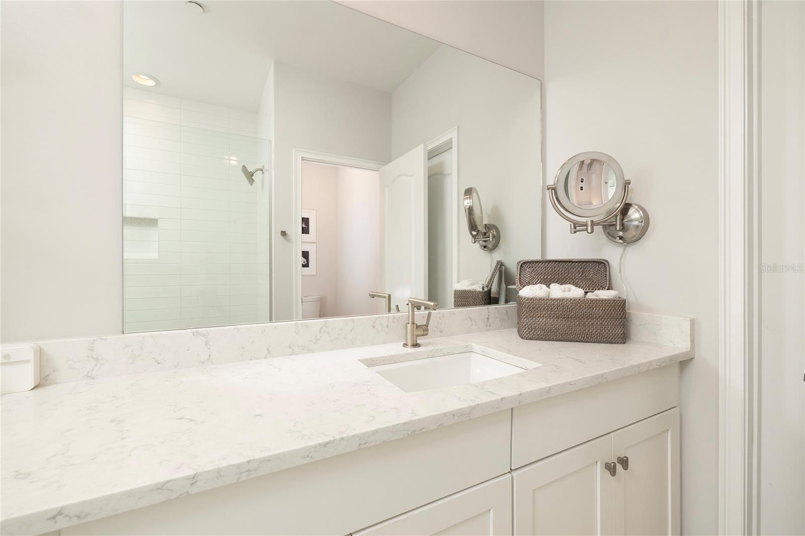 Large Primary Bathroom with dual sinks, oversized shower and access to second walk-in closet