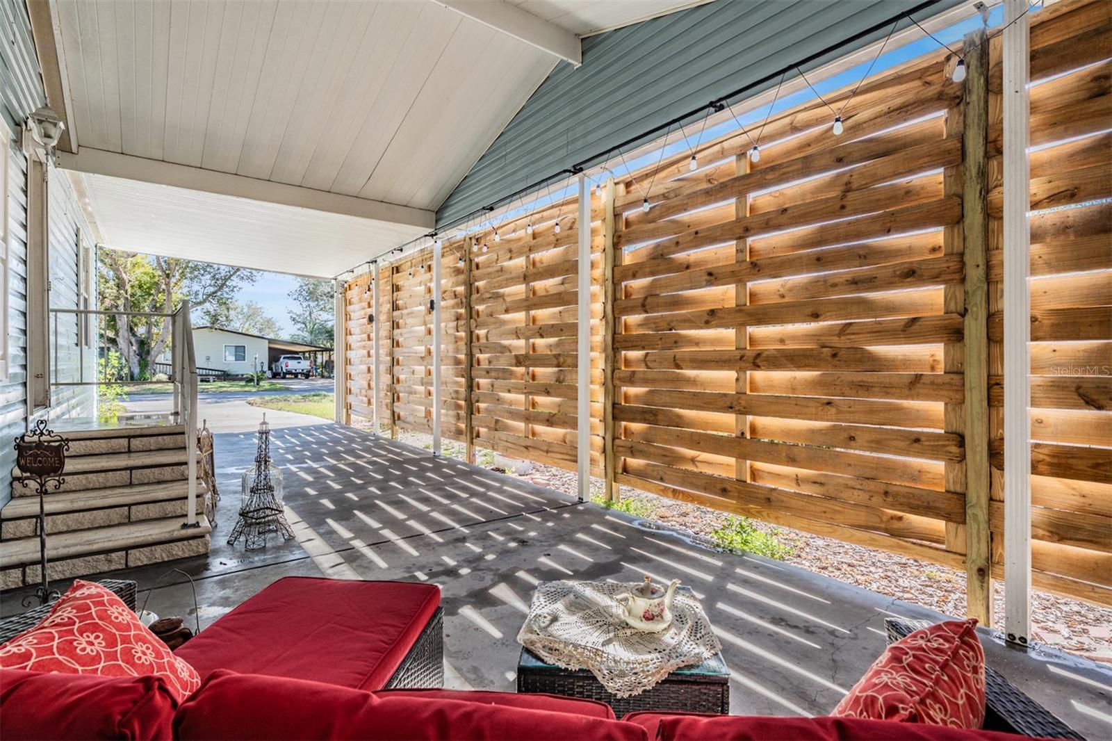 Wooden basket weave fencing in carport for privacy