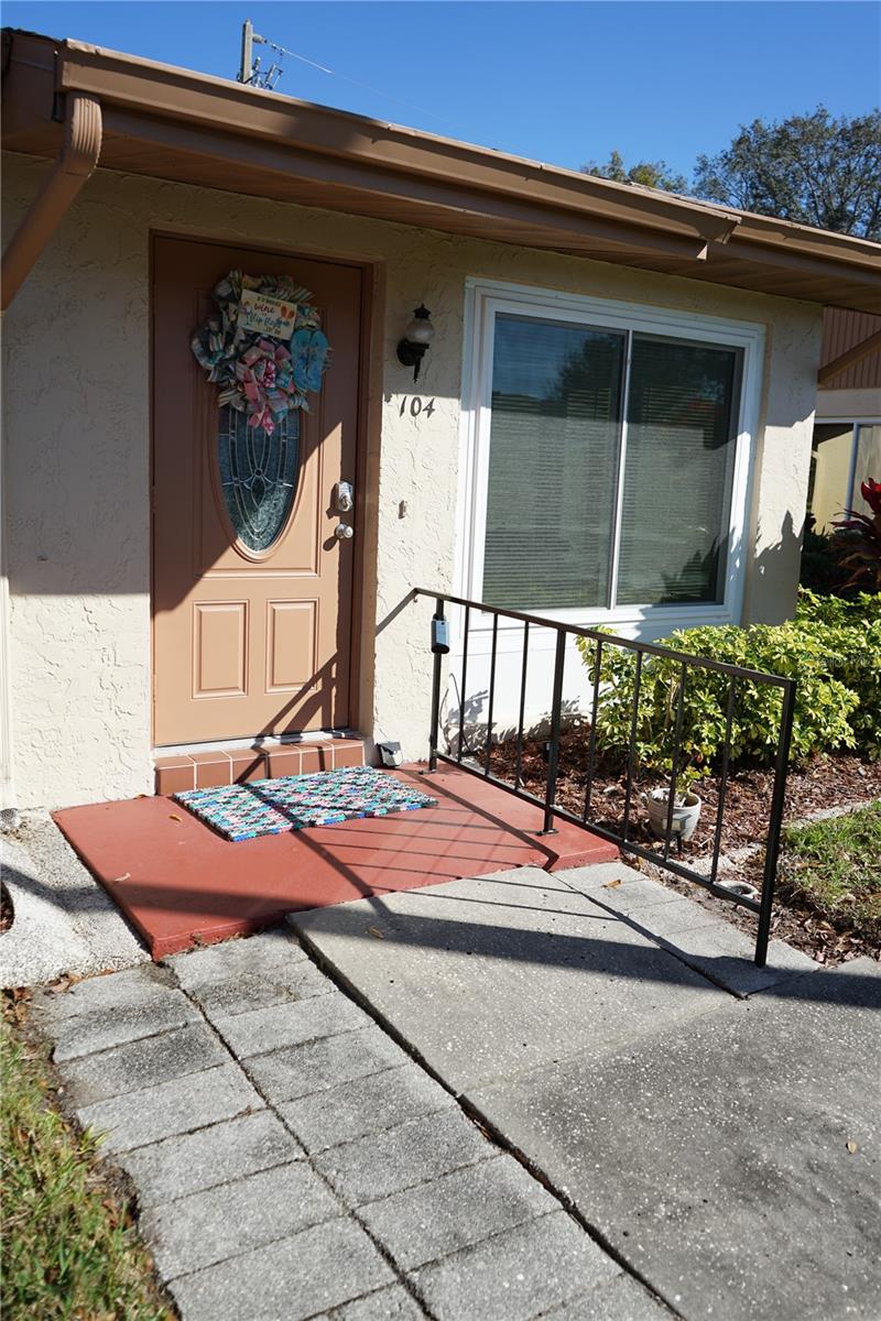 walkway up to door has a ramp and hand rail