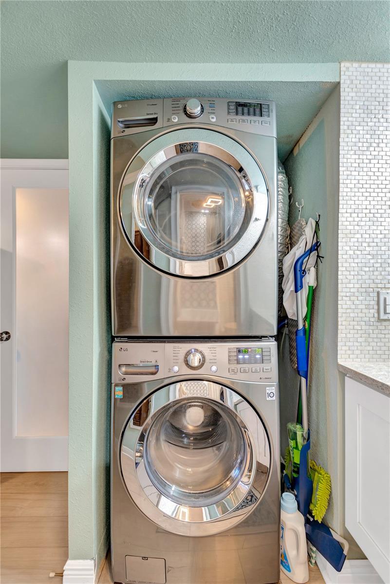 Adjacent to vanity is your own stackable washer/dryer combination.