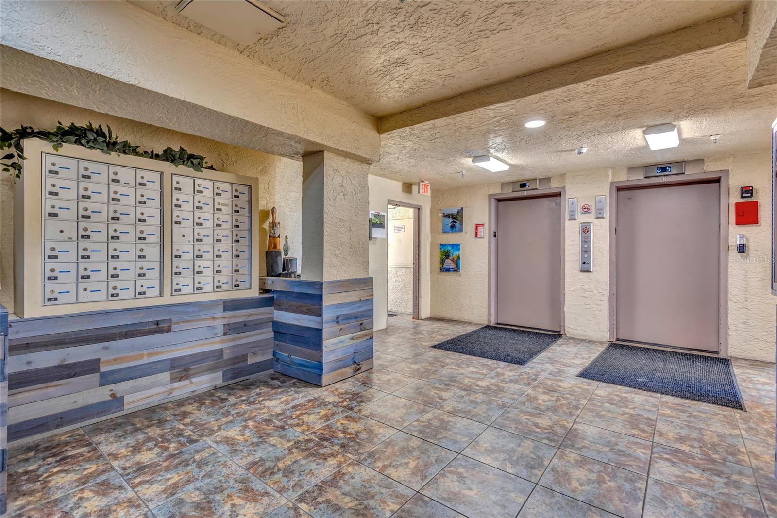 Building III ground floor lobby with dual elevators, mail boxes and notice boards for your information.