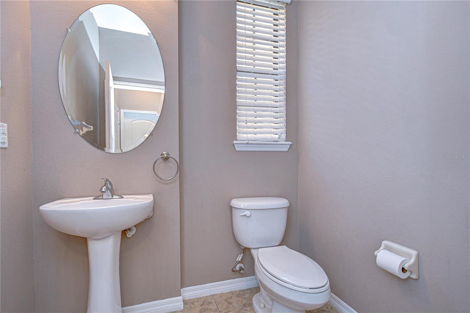 stylish half-bathroom with a sleek pedestal sink and classic fixtures.