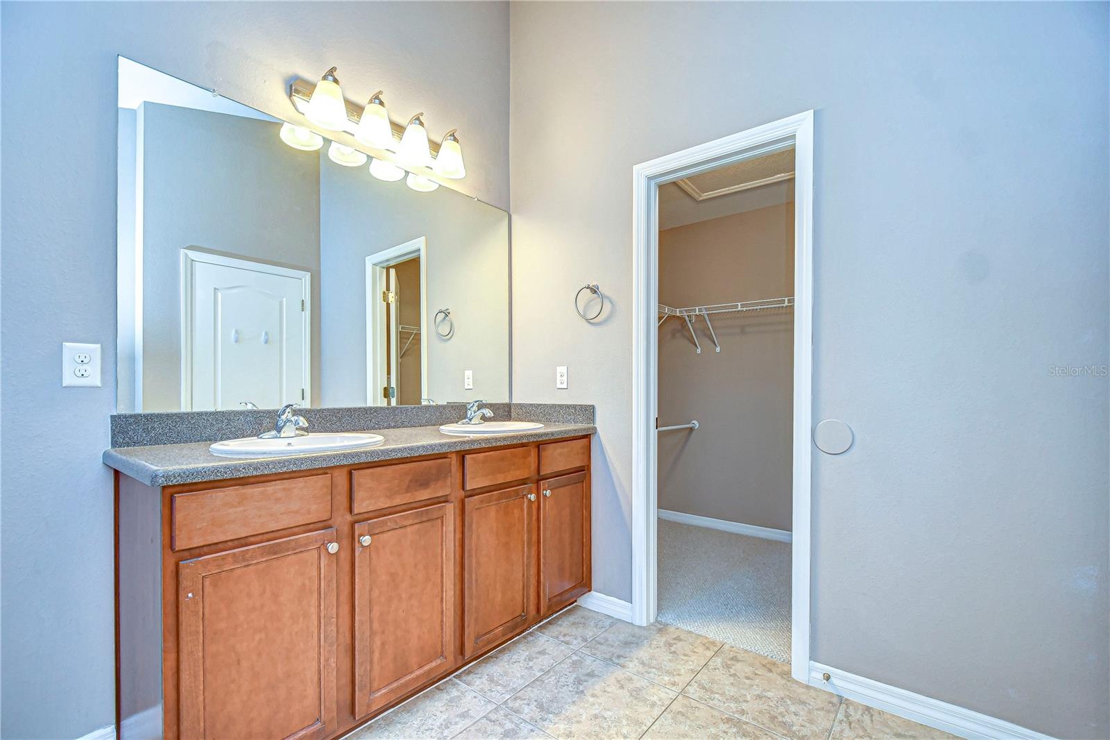 Dual vanity paves the way to the expansive closet.