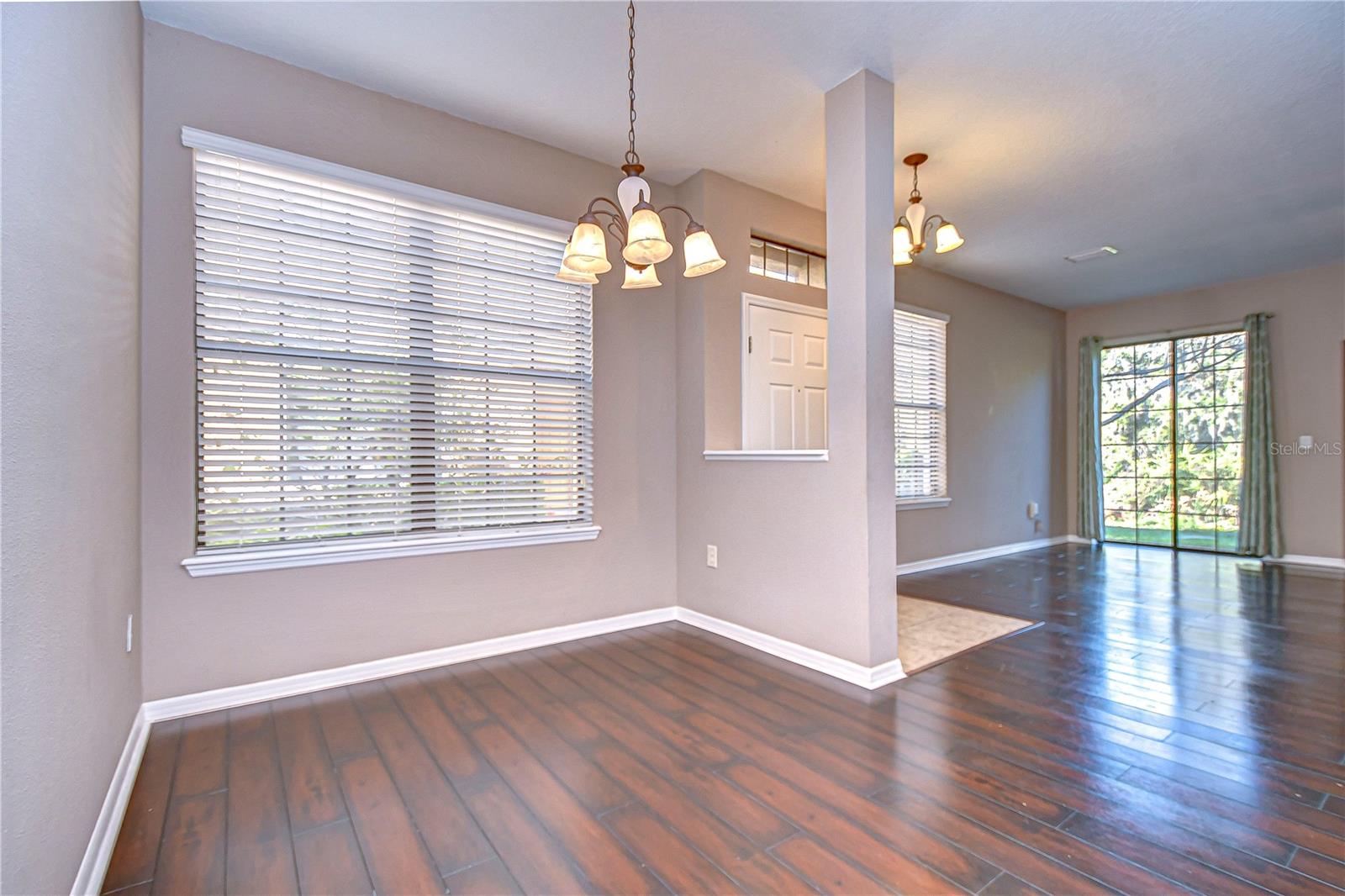 Sunlight streams through ample windows, illuminating the space and creating a warm ambiance in this open dining space