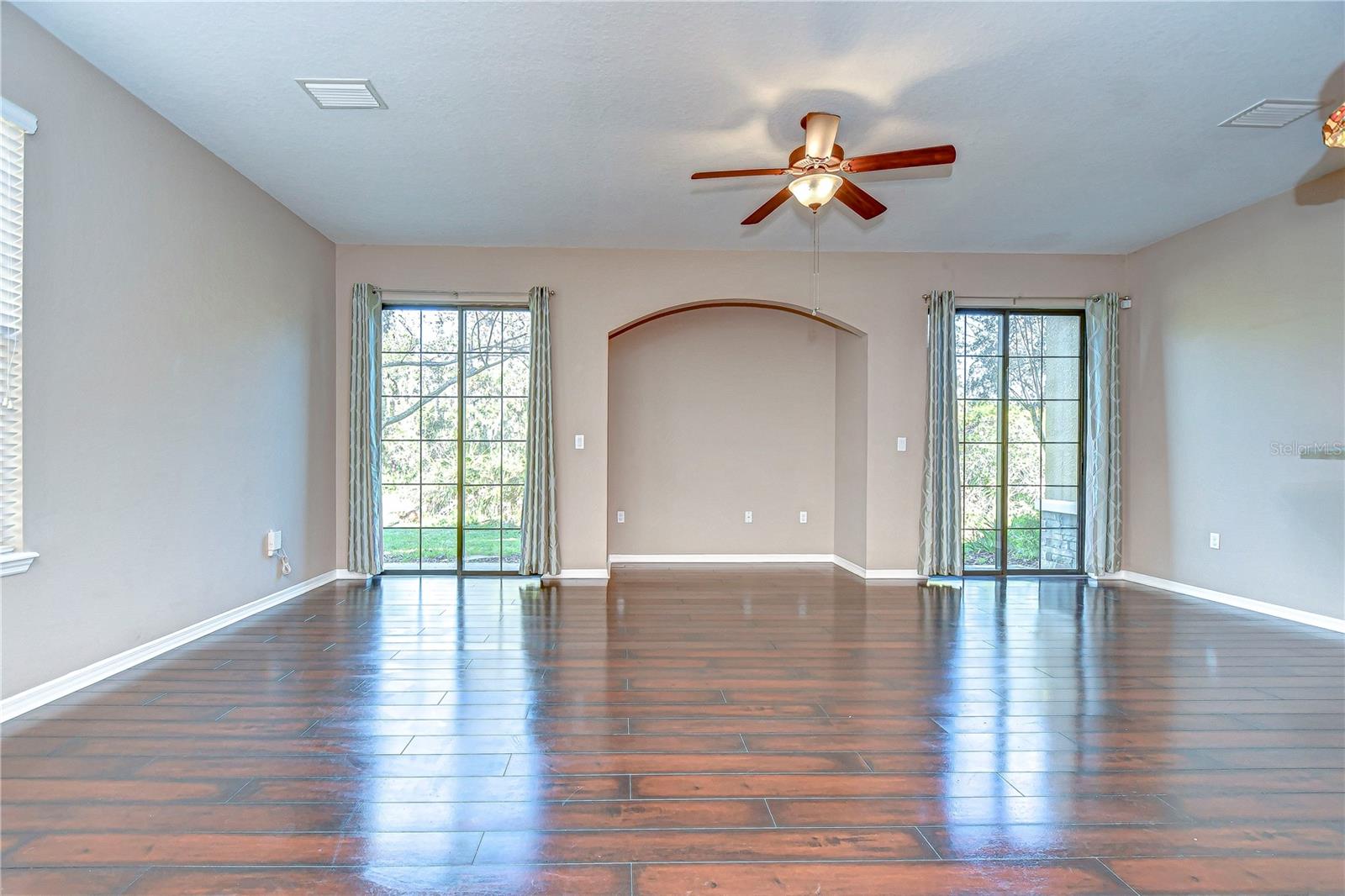 Step into this luminous living area featuring sleek floors and MASSIVE windows.