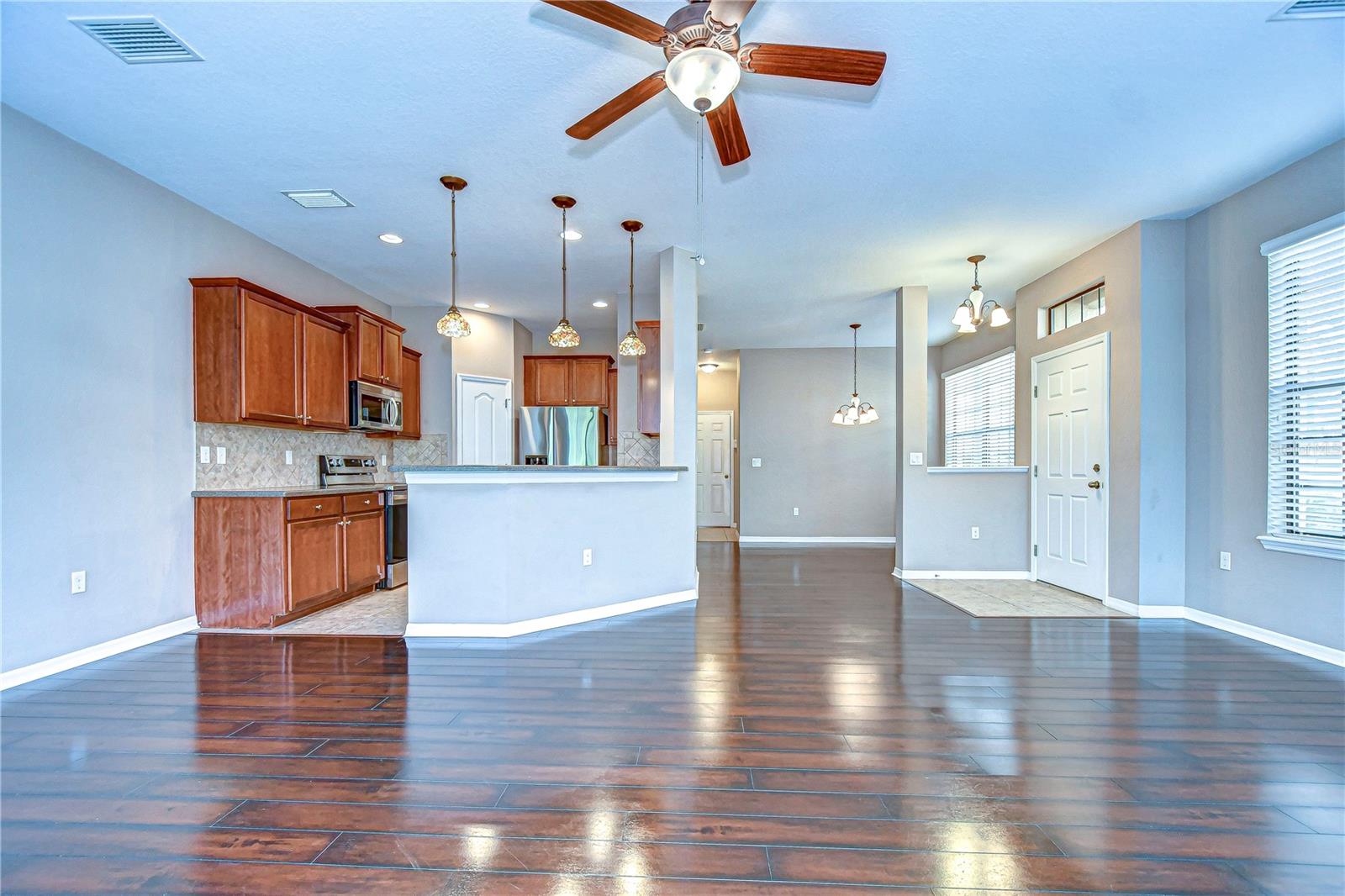 The modern kitchen, boasts stainless steel appliances and charming pendant lights