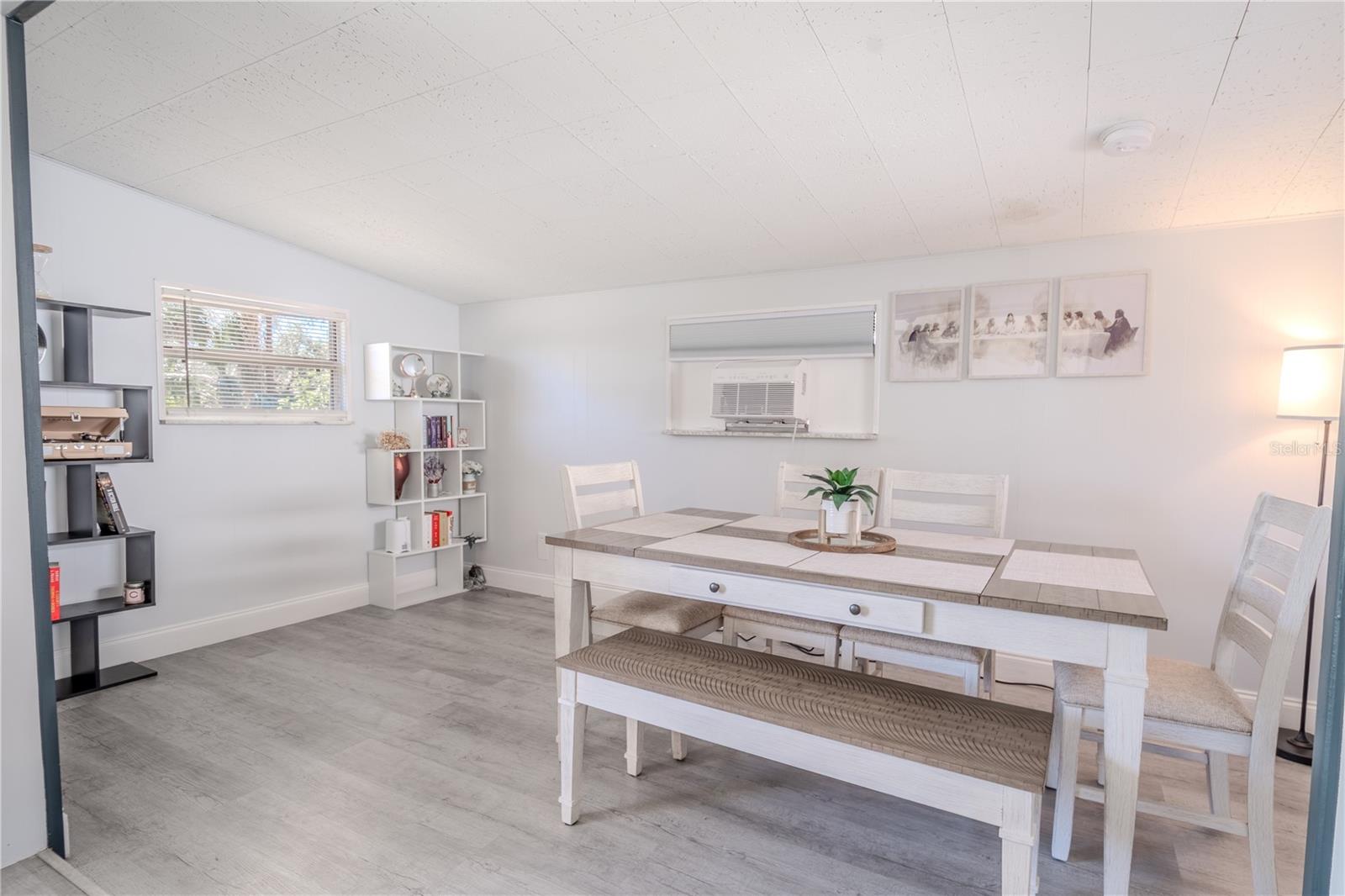 The dining room features neutral tones and vinyl flooring.