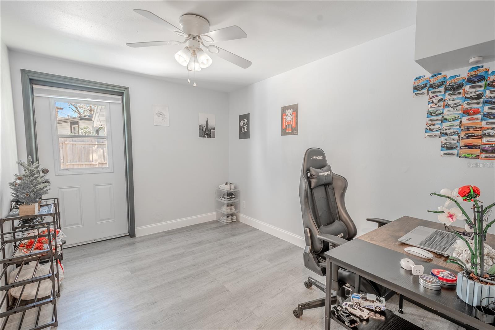 Bedroom 2 features vinyl flooring, a ceiling fan with light kit and a built in closet.