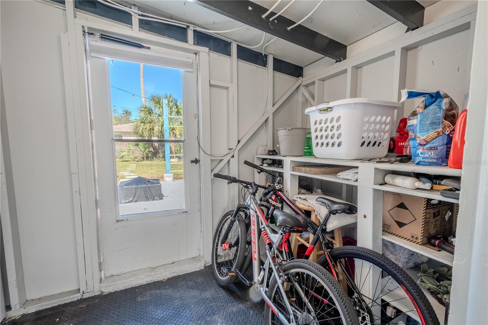 The laundry room has built in shelving and room for additional storage.