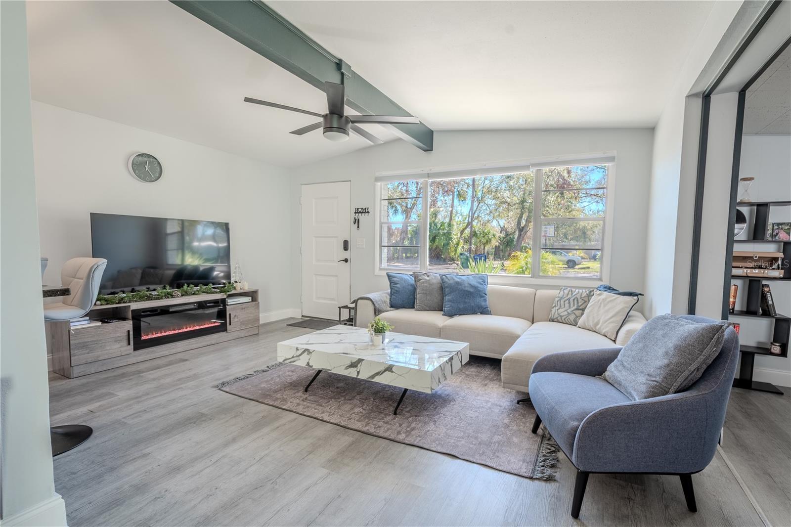 The living room view is framed by a large picture window.